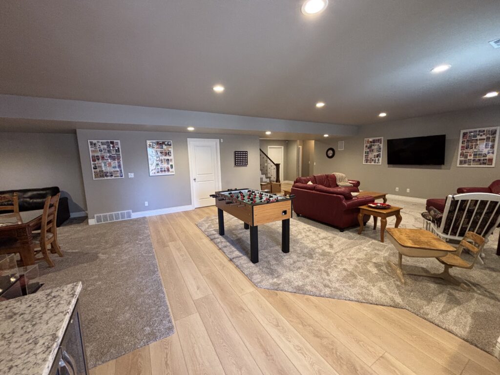 Open finished basement living room with game area and sectional sofa